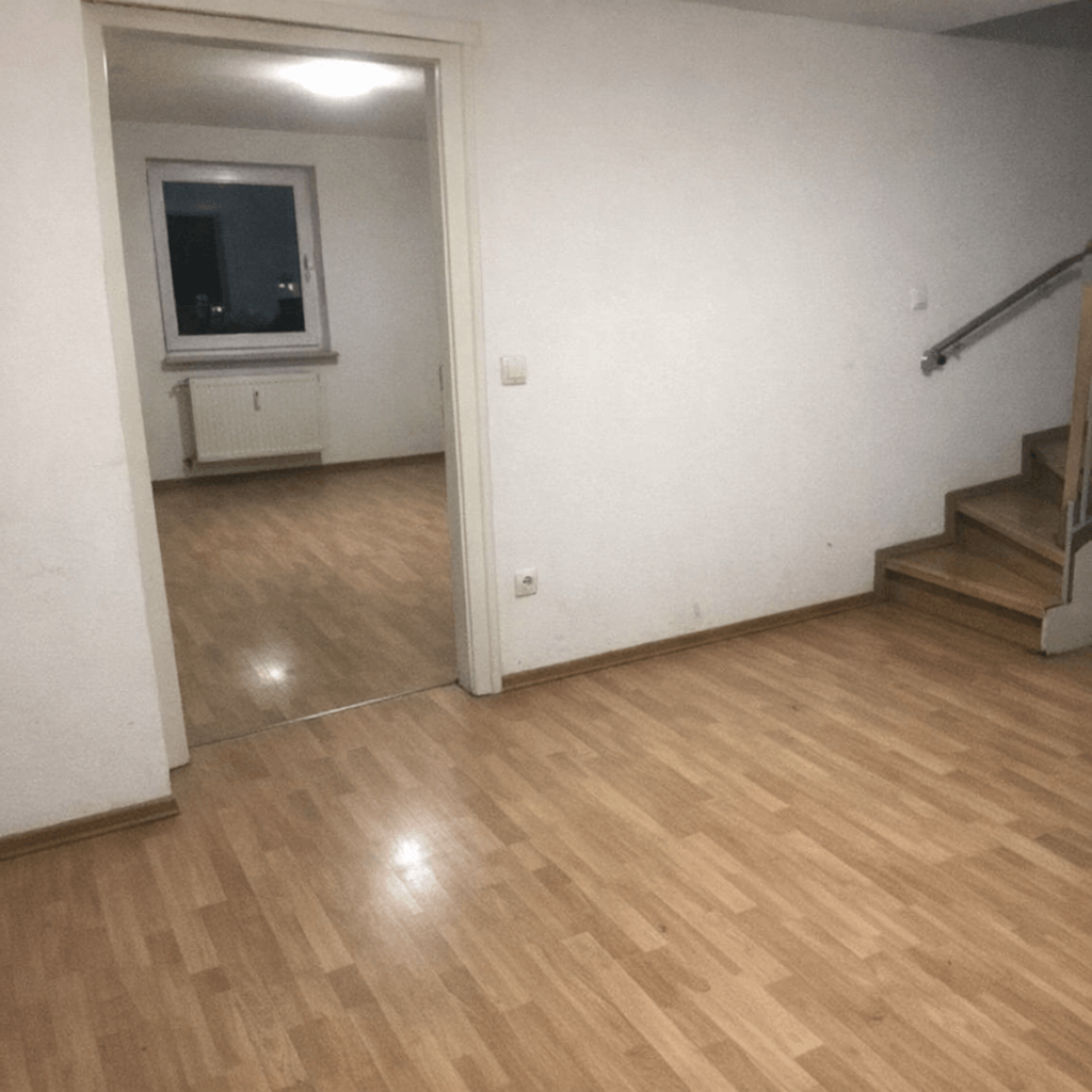 Ausgeräumter Flur eines Mehrfamilienhauses mit geschütztem Treppenlauf